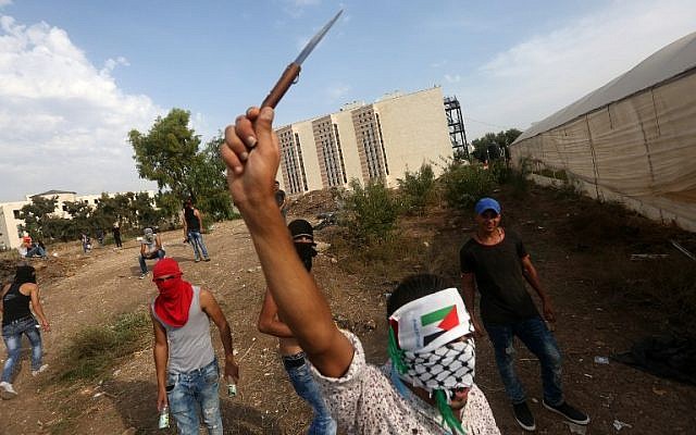 A Palestinian youth raises a knife during clashes with Israeli security forces (unseen) in the West Bank city of Tulkarem on October 18, 2015. (AFP/JAAFAR ASHTIYEH) A Palestinian youth raises a knife during clashes with Israeli security forces (unseen) in the West Bank city of Tulkarem on October 18, 2015. (AFP/JAAFAR ASHTIYEH)