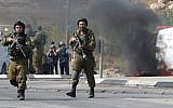 File: IDF soldiers stand guard south of the West Bank city of Hebron, October 20, 2015. (AFP/Hazem Bader)