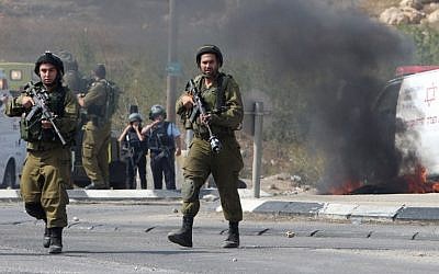 File: IDF soldiers stand guard south of the West Bank city of Hebron, October 20, 2015. (AFP/Hazem Bader)