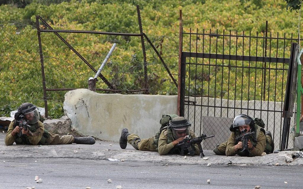 Israeli soldiers during clashes following Friday prayers on October 23, 2015, in the West Bank town of Hebron. (AFP/HAZEM BADER) Israeli soldiers during clashes following Friday prayers on October 23, 2015, in the West Bank town of Hebron. (AFP/HAZEM BADER)