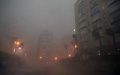 Cars drive through the haze in the Israeli Mediterranean town of Netanya, north of Tel Aviv on October 25, 2015 as a storm hits the area.(AFP/ JACK GUEZ)