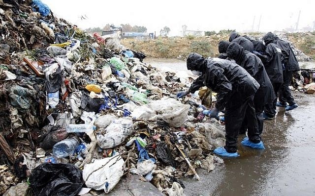 Lebanese activists take part in a campaign to clean the Beirut river from garbage during heavy rain on October 25, 2015. There are fears the uncollected waste, coupled with the looming rainy season, could spread diseases such as cholera among the population. (AFP PHOTO / ANWAR AMRO)