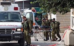Israeli soldiers evacuate, on a stretcher, the body of Palestinian Raed Jarradat, who had stabbed and seriously wounded a soldier before he was shot dead, on Monday, October 26, 2015, near the West Bank city of Hebron (AFP PHOTO/HAZEM BADER)
