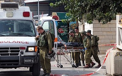 Israeli soldiers evacuate, on a stretcher, the body of Palestinian Raed Jarradat, who had stabbed and seriously wounded a soldier before he was shot dead, on Monday, October 26, 2015, near the West Bank city of Hebron (AFP PHOTO/HAZEM BADER)
