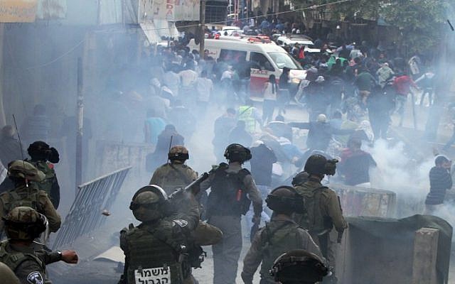 Illustrative: Israeli security forces fire tear gas canisters to disperse Palestinian protesters during a demonstration in the West Bank city of Hebron, on October 27, 2015. (AFP Photo/Hazem Bader) Illustrative: Israeli security forces fire tear gas canisters to disperse Palestinian protesters during a demonstration in the West Bank city of Hebron, on October 27, 2015. (AFP Photo/Hazem Bader)