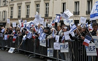People listen to a speech by the President of the French Union of Jewish Students (UEJF) during a pro-Israel gathering outside the Israeli embassy in Paris on October 18, 2015. Placards read 'Self-defense is a right.' (AFP PHOTO/FRANCOIS GUILLOT)