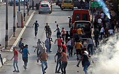 Palestinian demonstrators run for cover from tear gas fired by Israeli security forces during clashes in the West Bank town of Bethlehem on October 2, 2015. (Musa al Shaer/AFP)