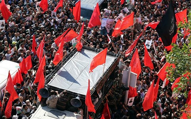 Illustrative: Iranian men carry portraits of Iran's Revolutionary Guards Brigadier General Hossein Hamedani during his funeral in Tehran on October 11, 2015. General Hamedani was killed by Islamic State group jihadists "during an advisory mission" in the northern region of Aleppo, according to a Guards statement. (AFP/ATTA KENARE) Illustrative: Iranian men carry portraits of Iran's Revolutionary Guards Brigadier General Hossein Hamedani during his funeral in Tehran on October 11, 2015. General Hamedani was killed by Islamic State group jihadists "during an advisory mission" in the northern region of Aleppo, according to a Guards statement. (AFP/ATTA KENARE)
