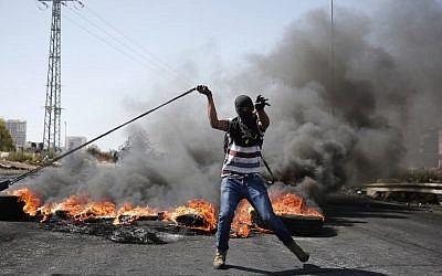 A Palestinian protester uses a slingshot to throw stones towards Israeli security forces during clashes in Beit El, near the West Bank city of Ramallah, on October 11, 2015. (AFP/Abbas Momani) A Palestinian protester uses a slingshot to throw stones towards Israeli security forces during clashes in Beit El, near the West Bank city of Ramallah, on October 11, 2015. (AFP/Abbas Momani)