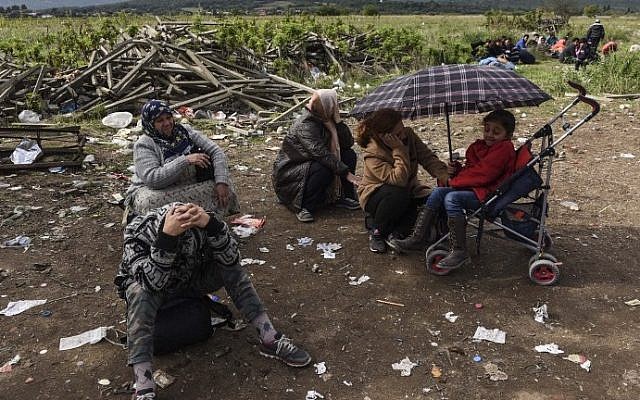 Migrants and asylum seekers rest after crossing the Greek-Macedonian border near Gevgelija, on October 2, 2015. (AFP/ ARMEND NIMANI)