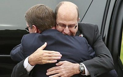 US Defense Secretary Ashton Carter embraces Defense Minister Moshe Ya'alon, facing forward, at the National Defense University in Washington, DC on October 27, 2015. (AFP/YURI GRIPAS)