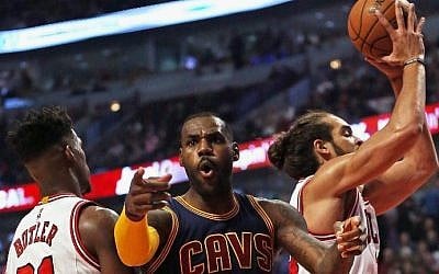 LeBron James of the Cleveland Cavaliers complains to a referee as he is trapped between Jimmy Butler and Joakim Noah of the Chicago Bulls during the season opening game at the United Center on October 27, 2015 in Chicago, Illinois. (Jonathan Daniel/Getty Images/AFP)