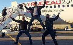 Canadian Liberal leader Justin Trudeau, center, clowns around with campaign team members Tommy Desfosses, left, and Adam Scotti after landing in Montreal, Monday, Oct. 19, 2015. (Andy Blatchford/The Canadian Press via AP)
