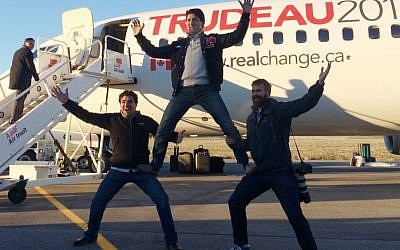 Canadian Liberal leader Justin Trudeau, center, clowns around with campaign team members Tommy Desfosses, left, and Adam Scotti after landing in Montreal, Monday, Oct. 19, 2015. (Andy Blatchford/The Canadian Press via AP)