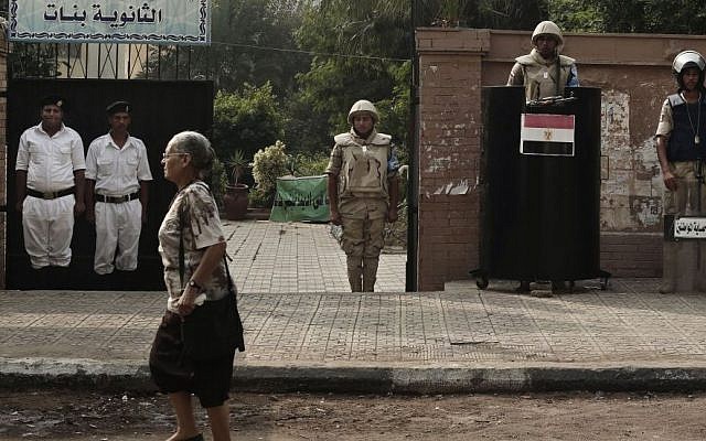 File: An Egyptian woman walks past the entrance of a polling center being guarded by army and police forces before polls open during the first round of the parliamentary election in Giza, Cairo, Egypt, Sunday, Oct. 18, 2015. (AP/Nariman El-Mofty)