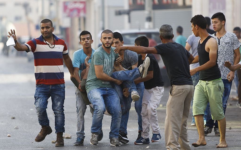 Illustrative: Palestinians carry a man who was injured in clashes with Israeli soldiers in the West Bank city of Jenin, Sunday, Oct. 4, 2015. (AP Photo/Majdi Mohammed)