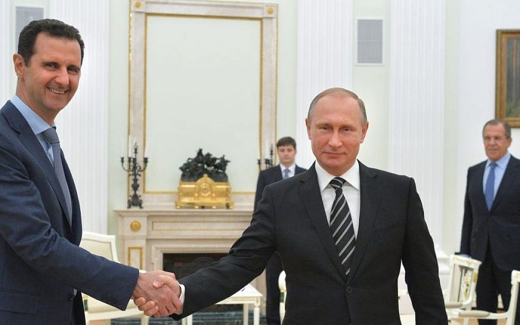 Russian President Vladimir Putin (center), shakes hands with Syrian President Bashar Assad as Russian Foreign Minister Sergey Lavrov (right), looks on in the Kremlin in Moscow, Russia, October 20, 2015. (Alexei Druzhinin, RIA-Novosti/Kremlin Pool Photo via AP)