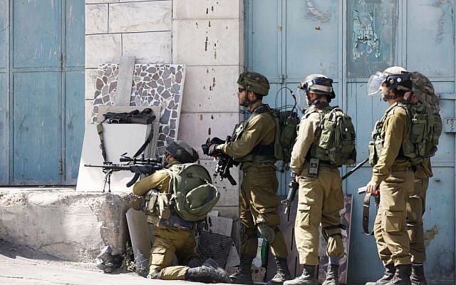 Illustrative: IDF soldiers stand with their weapons during clashes with Palestinian demonstrators in the West Bank city of Hebron, on Tuesday, October 13, 2015. (AP Photo/Nasser Shiyoukhi) Illustrative: IDF soldiers stand with their weapons during clashes with Palestinian demonstrators in the West Bank city of Hebron, on Tuesday, October 13, 2015. (AP Photo/Nasser Shiyoukhi)
