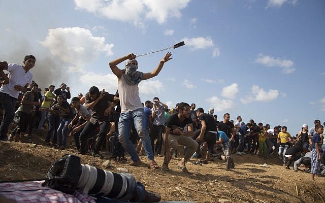 A Palestinian protester hurls stones at Israeli soldiers during clashes on the Israeli border in eastern Gaza City, Friday, Oct. 9, 2015.  (AP Photo/Adel Hana)