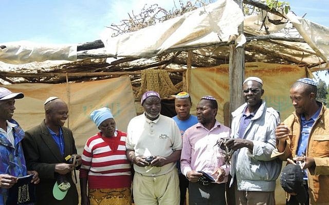 The elders of the community stand in front of the synagogue. The synagogue is built on land belonging to Sarah Mumbi, in the blue head covering, and her husband Avraham Ndungu Mbugua, next to her in the purple kippah. (Melanie Lidman/Times of Israel)