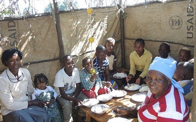 Members of the Kaskuku Jewish community eat lunch in the Sukkah on October 5, 2015. (Melanie Lidman/Times of Israel)