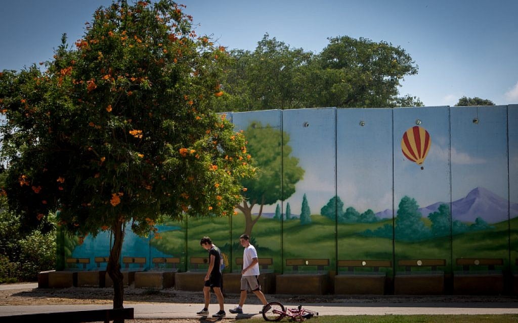 Israeli children play near a colorfully painted  concrete protective shelter in the kibbutz of Nahal Oz. July 6, 2015. (Miriam Alster/FLASH90)