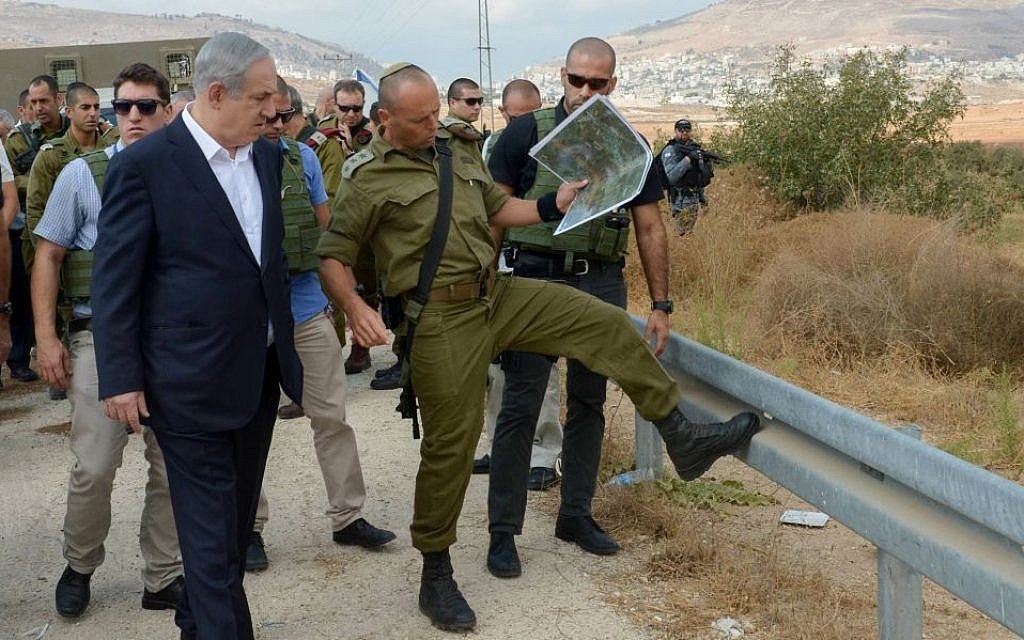 Benjamin Netanyahu with army officials at the site of a terror attack in the West Bank on October 6, 2015. Amos Ben Gershom/GPO)