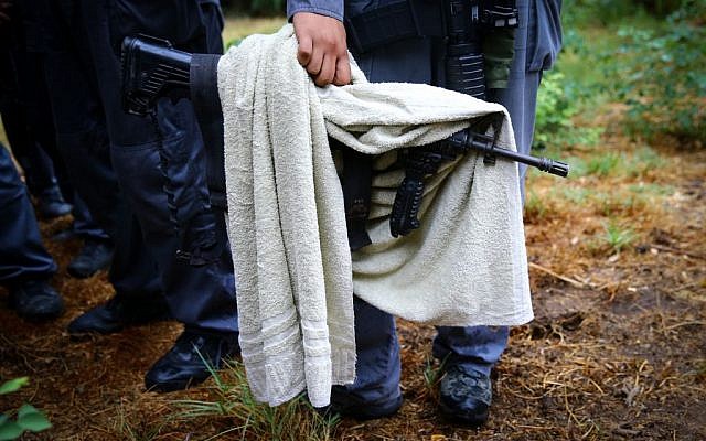 Israeli security personnel hold the weapon which a Palestinian man grabbed from an IDF soldier after stabbing and injuring him, in Kiryat Gat on October 07, 2015. (FLASH90)