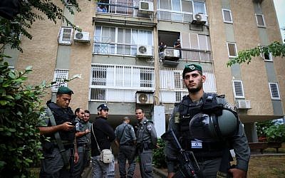Security personnel are seen outside an apartment building in the southern Israeli city of Kiryat Gat in to which a Palestinian attacker escaped after stabbing a soldier on October 7, 2015. (FLASH90)