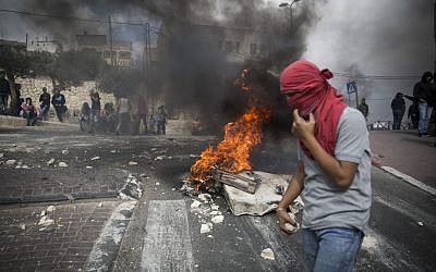 Palestinian youth holding rocks during clashes with Israeli police in the East Jerusalem neighborhood of Sur Baher on October 7, 2015. (Hadas Parush/Flash90)