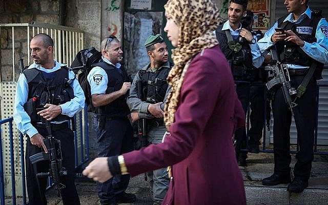 A Palestinian woman walks past Israeli policemen on the Via Dolorosa street in the Muslim Quarter in Jerusalem's Old City on October 8, 2015. (Hadas Parush/Flash90) A Palestinian woman walks past Israeli policemen on the Via Dolorosa street in the Muslim Quarter in Jerusalem's Old City on October 8, 2015. (Hadas Parush/Flash90)