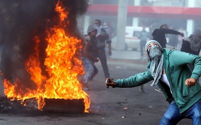 A Palestinian protester hurls stones during clashes with Israeli forces outside Beit El, near the West Bank city of Ramallah on October 9, 2015. (Flash90) A Palestinian protester hurls stones during clashes with Israeli forces outside Beit El, near the West Bank city of Ramallah on October 9, 2015. (Flash90)