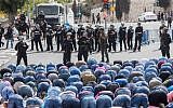 Palestinians pray as Israeli policemen watch in the East Jerusalem neighborhood of Wadi al-Joz, October 9, 2015. Israeli police declared an age limit on Friday for Palestinians wanting to enter the Old City, only allowing males above the age of 45 and all females to enter. (Yonatan Sindel/Flash90)