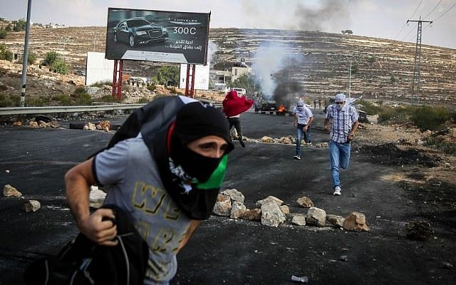 Illustrative photo of Palestinian protesters hurling stones towards Israeli troops during clashes by the Jewish settlement of Bet El, near the West Bank city of Ramallah October 10, 2015. (FLASH90)