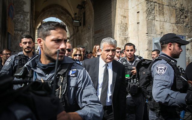 Yesh Atid party leader Yair Lapid surrounded by policemen during a visit to the Lion's Gate in Jerusalem's Old City, the site of an attempted stabbing attack on October 12, 2015. (Hadas Parush/Flash90)