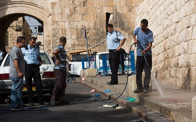 A man cleans the scene after an attempted stabbing of a police officer outside Lions' Gate in the Old City of Jerusalem on October 12, 2015. (Photo by Yonatan Sindel/Flash90) A man cleans the scene after an attempted stabbing of a police officer outside Lions' Gate in the Old City of Jerusalem on October 12, 2015. (Photo by Yonatan Sindel/Flash90)