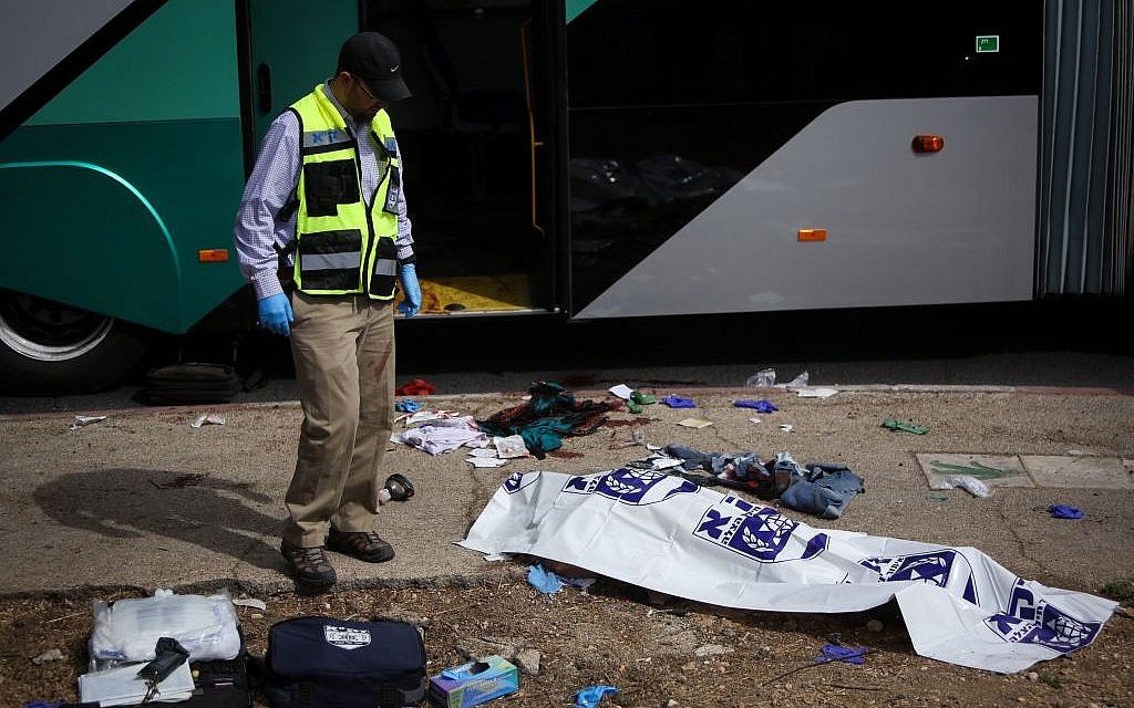 Rescue personnel stand near a victim who was killed in a terror attack in the Armon Hanatziv neighborhood of Jerusalem. October 13, 2015. (Yonatan Sindel/FLASH90)