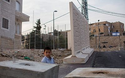 A Palestinian child stands near concrete walls in the East Jerusalem neighborhood of Jabel Mukaber, October 18, 2015. (Yonatan Sindel/Flash90)