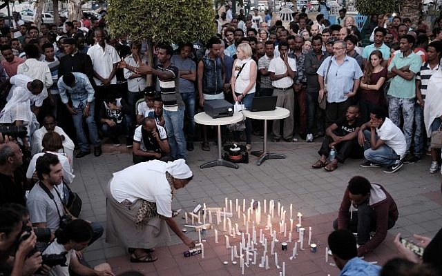 Sr Azezet Kidane, a Comboni Sister originally from Eritrea, lights a memorial candle for Haftom Zarhum. About 200 Israelis attended to show support. (Tomer Neuberg/Flash90)