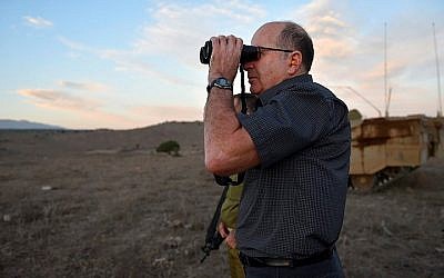 Defense Minister Moshe Ya'alon looks through binoculars during a visit at an army exercise of the Armored Corps, in the Golan Heights on October 22, 2015. (Ariel Hermoni/Ministry of Defense)
