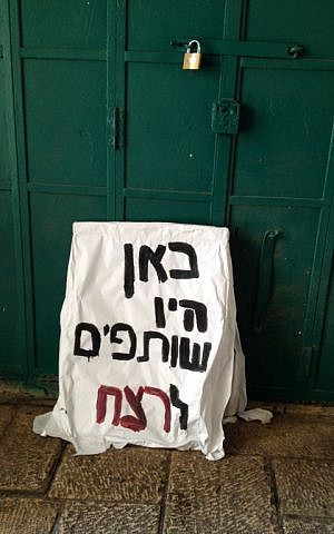 A sign reading 'here were accomplices to the murder,' lies against the shuttered door of a Palestinian shop on Hagai street, October 8, 2015 (Elhanan Miller/Times of Israel) A sign reading 'here were accomplices to the murder,' lies against the shuttered door of a Palestinian shop on Hagai street, October 8, 2015 (Elhanan Miller/Times of Israel)