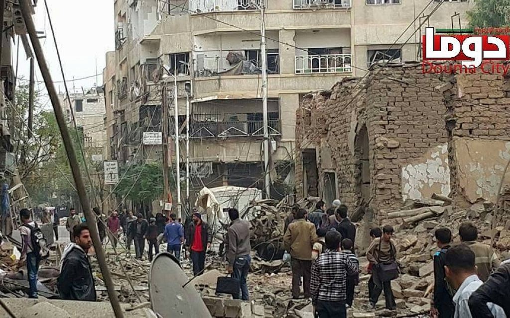 File. In this photo provided by the Syrian anti-government activist group Douma Revolution, people gather near damaged buildings in the aftermath of an airstrike that activists said was carried out by Russia, in Douma, Syria, Thursday, October 29, 2015. (Douma Revolution via AP) File. In this photo provided by the Syrian anti-government activist group Douma Revolution, people gather near damaged buildings in the aftermath of an airstrike that activists said was carried out by Russia, in Douma, Syria, Thursday, October 29, 2015. (Douma Revolution via AP)