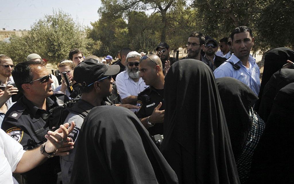 In this Thursday, July 28, 2015 photo, Palestinian women confront a group of religious Jews escorted by Israeli police at the Temple Mount in Jerusalem.(AP/Mahmoud Illean)
