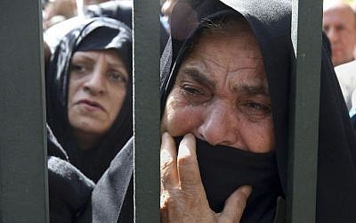 In this October 4, 2015, file photo, an Iranian mourner weeps during a funeral ceremony, attended by thousands of mourners in Tehran, Iran, for some of the pilgrims who were killed in a stampede during the hajj pilgrimage in Saudi Arabia in September 2015. (AP/Vahid Salemi, File)