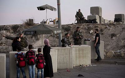 In this Thursday, Oct. 22, 2015 file photo, Israeli border police check Palestinians' ID cards at a checkpoint as they exit the Arab neighborhood of Issawiyeh in Jerusalem. (AP Photo/Oded Balilty)