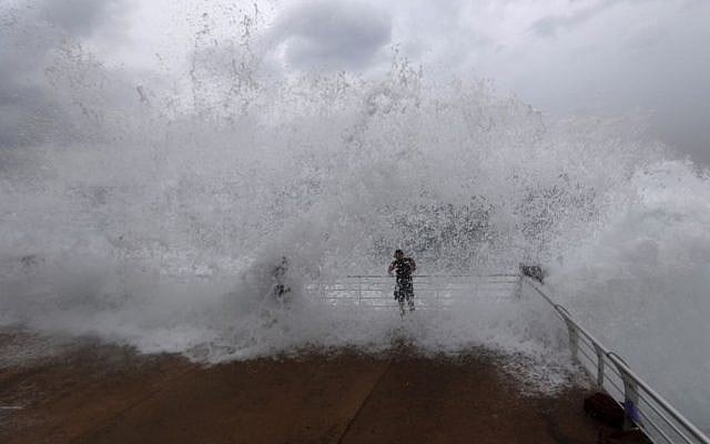 Lebanese men workout as waves crash over them on the seafront at the Corniche, or waterfront promenade, in Beirut, Lebanon on Oct. 25, 2015. (AP Photo/Hassan Ammar)