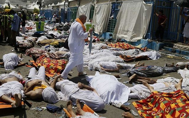 In this Thursday, Sept. 24, 2015 file photo, a Muslim pilgrim walks through the site where dead bodies are gathered in Mina, Saudi Arabia during the annual hajj pilgrimage. (AP) In this Thursday, Sept. 24, 2015 file photo, a Muslim pilgrim walks through the site where dead bodies are gathered in Mina, Saudi Arabia during the annual hajj pilgrimage. (AP)