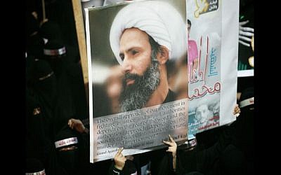 In this Sunday, Sept. 30, 2012 file photo, a Saudi anti-government protester carries a poster with the image of jailed Shiite cleric Sheik Nimr al-Nimr during the funeral of three Shiite Muslims allegedly killed by Saudi security forces in the eastern town of al-Awamiya, Saudi Arabia. (AP)
