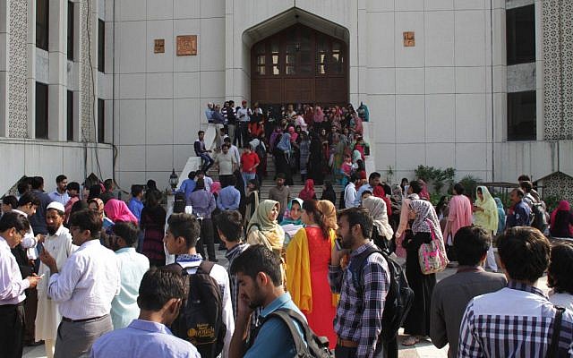 People stand outside their offices after a severe earthquake is felt in Lahore, Pakistan, Monday, Oct. 26, 2015. (Photo by AP Photo/K.M. Chaudary)