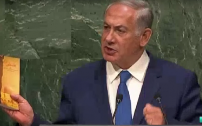 File: Prime Minister Benjamin Netanyahu holds up a collection of speeches by Iran's Ayatollah Ali Khamenei during an address to the UN General Assembly, October 1, 2015 (YouTube screenshot)